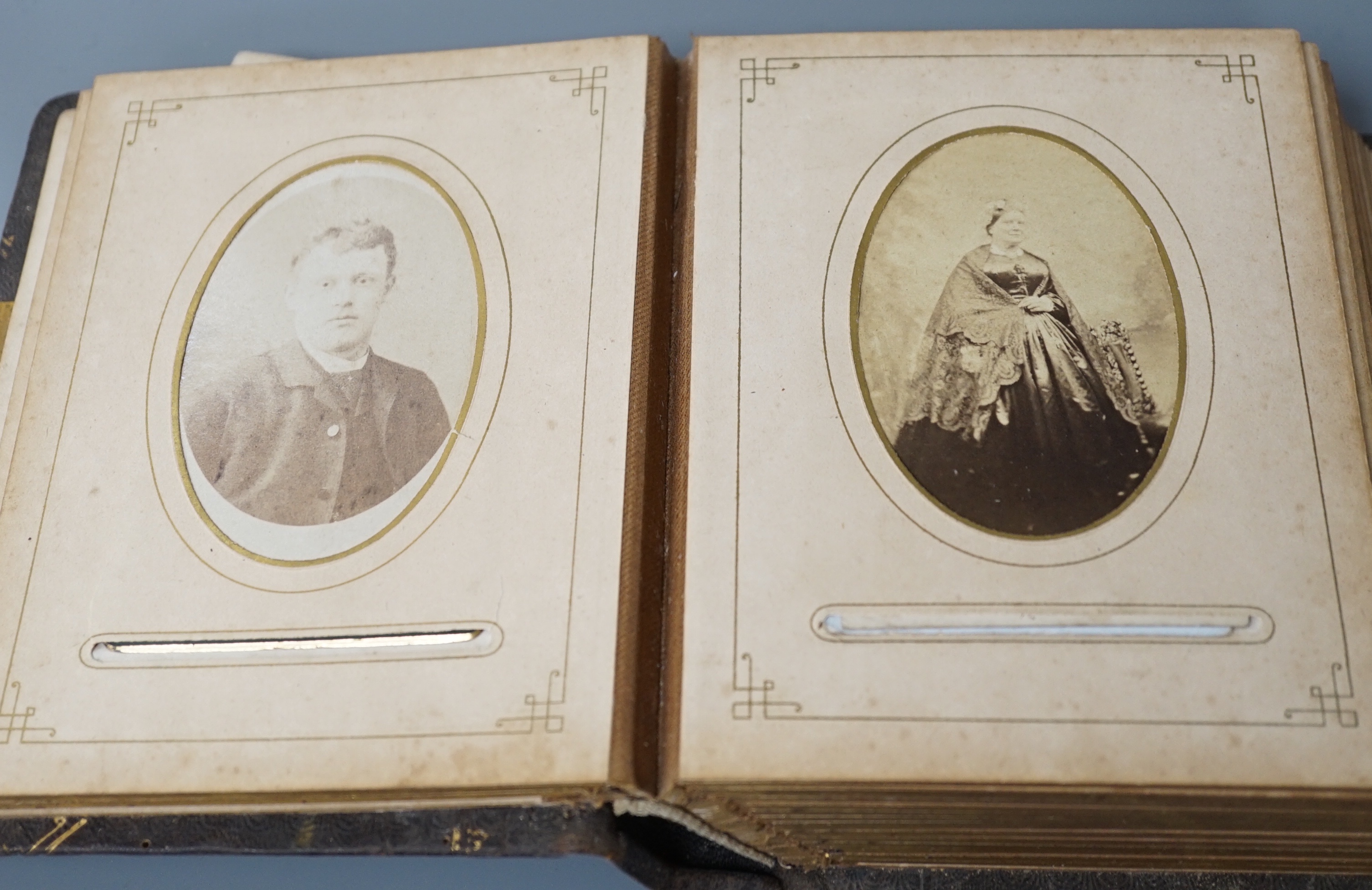A Victorian portrait photograph album in clasp bound book containing cabinet cards